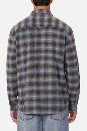 Someone is shown from the back against a plain, light background, wearing the Industrie Durango Long Sleeve Shirt in blue and gray plaid cotton with light blue jeans—perfect for everyday wear.