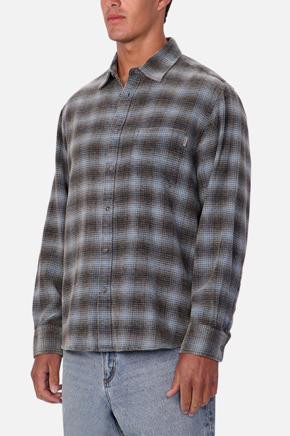 A person wearing the Industrie Durango Long Sleeve Shirt in gray and blue plaid with light blue jeans stands against a plain white background—a classic wardrobe essential.