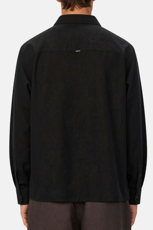 A person is shown from the back against a plain light background, wearing the Industrie The St Martins Shirt in black—a long-sleeve linen shirt with a regular fit—paired with dark pants.