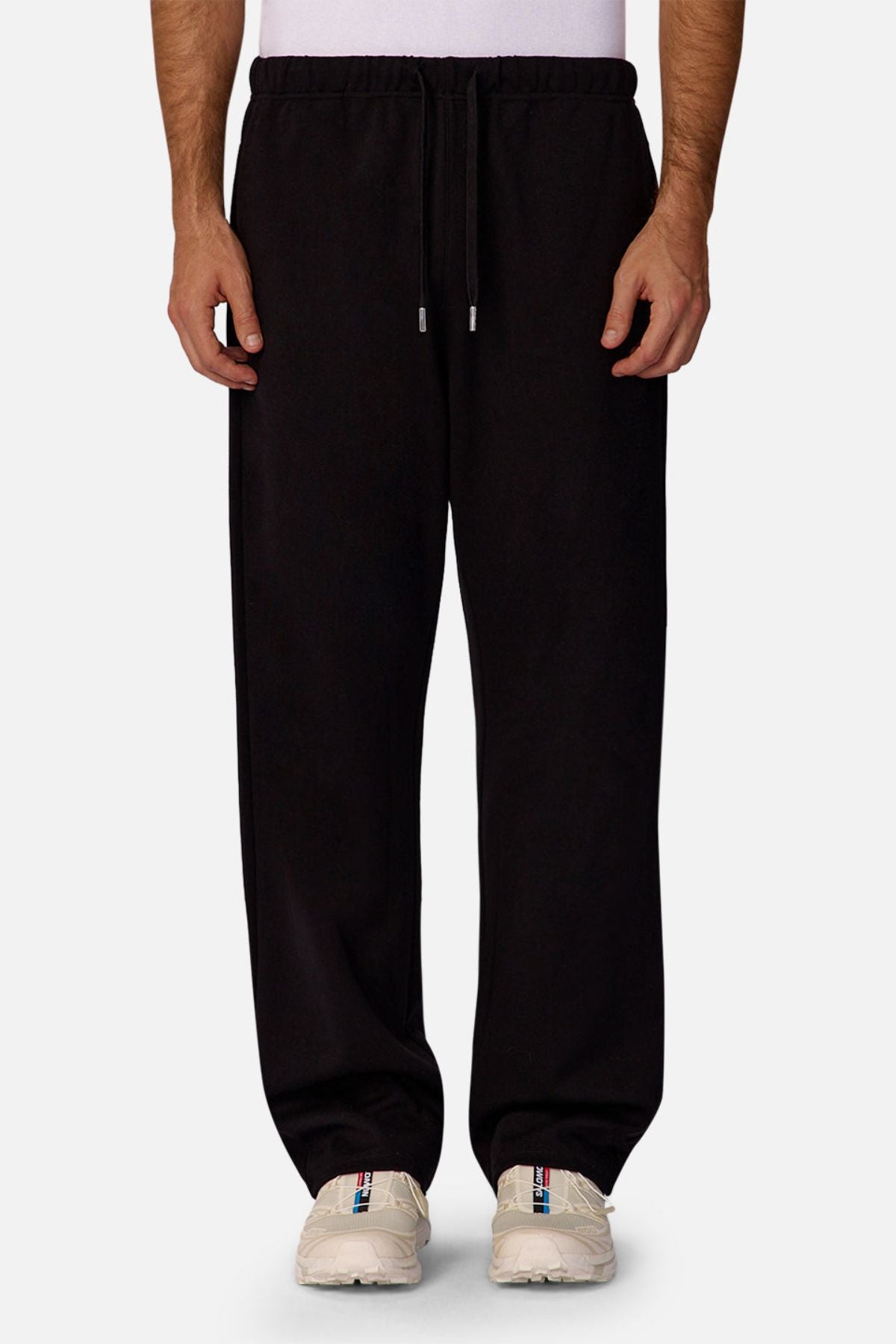 Dressed in Industrie The Astoria Lux Tech Trackpant and white sneakers, this waist-down shot against a light background captures casual style paired with premium comfort.