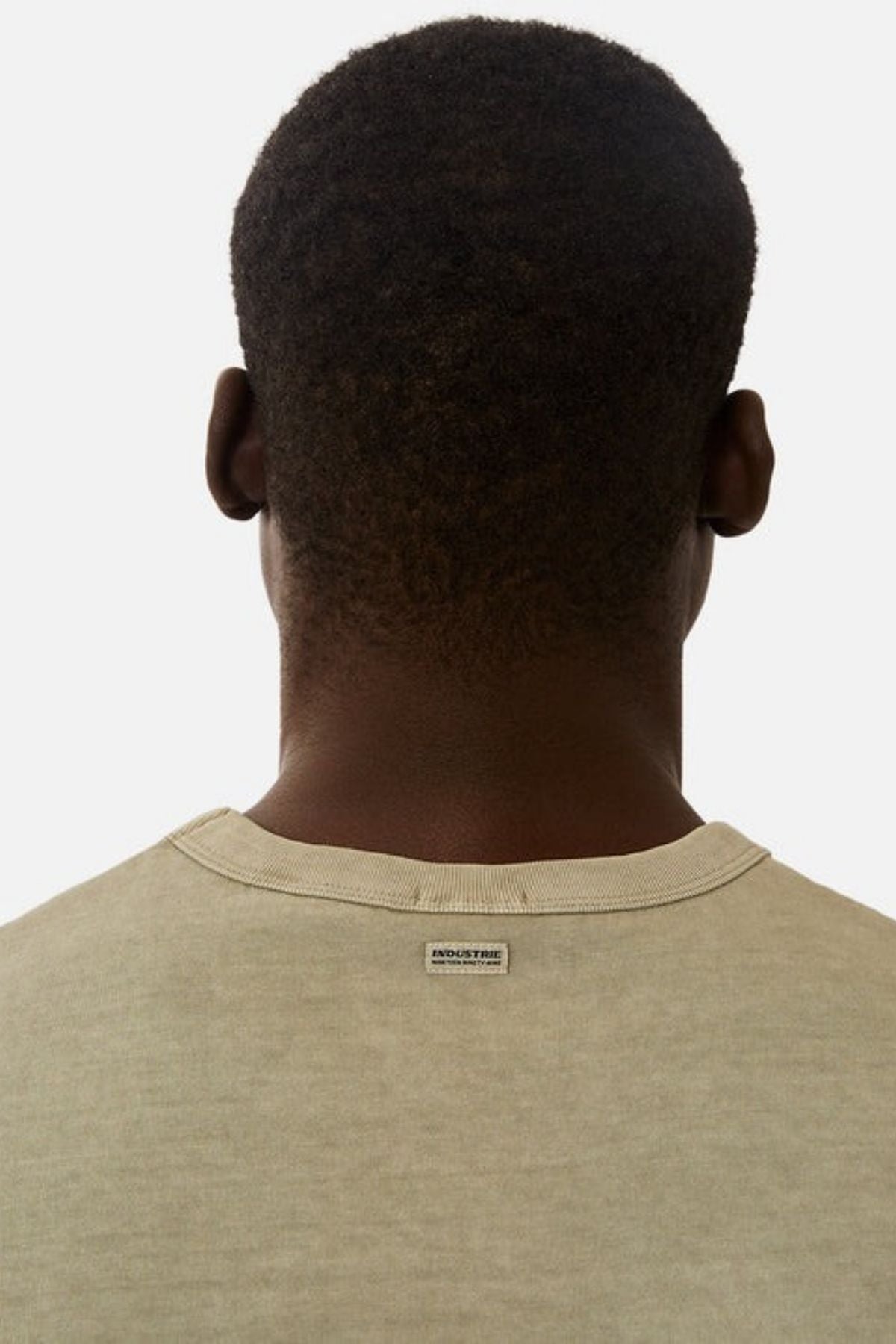 Rear view of a person with short hair, wearing the Industrie The Del Sur Sleeveless Tee in an oversized fit, crafted from 100% cotton. The focus is on the back of the head and shoulders against a plain background.