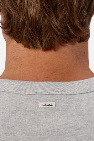 Close-up of the back of a person’s neck and head with light brown hair, wearing the gray Industrie The Del Sur Tee. A small white "Industrie" label is visible, showcasing the tee’s distinct oversized fit.