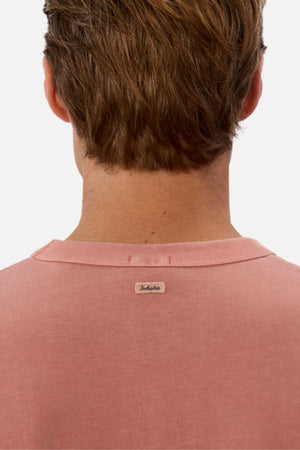 A person with short brown hair is shown from the back, wearing a pink Industrie The Del Sur Tee crafted from heavyweight fabric, featuring a small "Jack & Jones" label at the neckline. The oversized fit adds a modern touch against the plain white background.