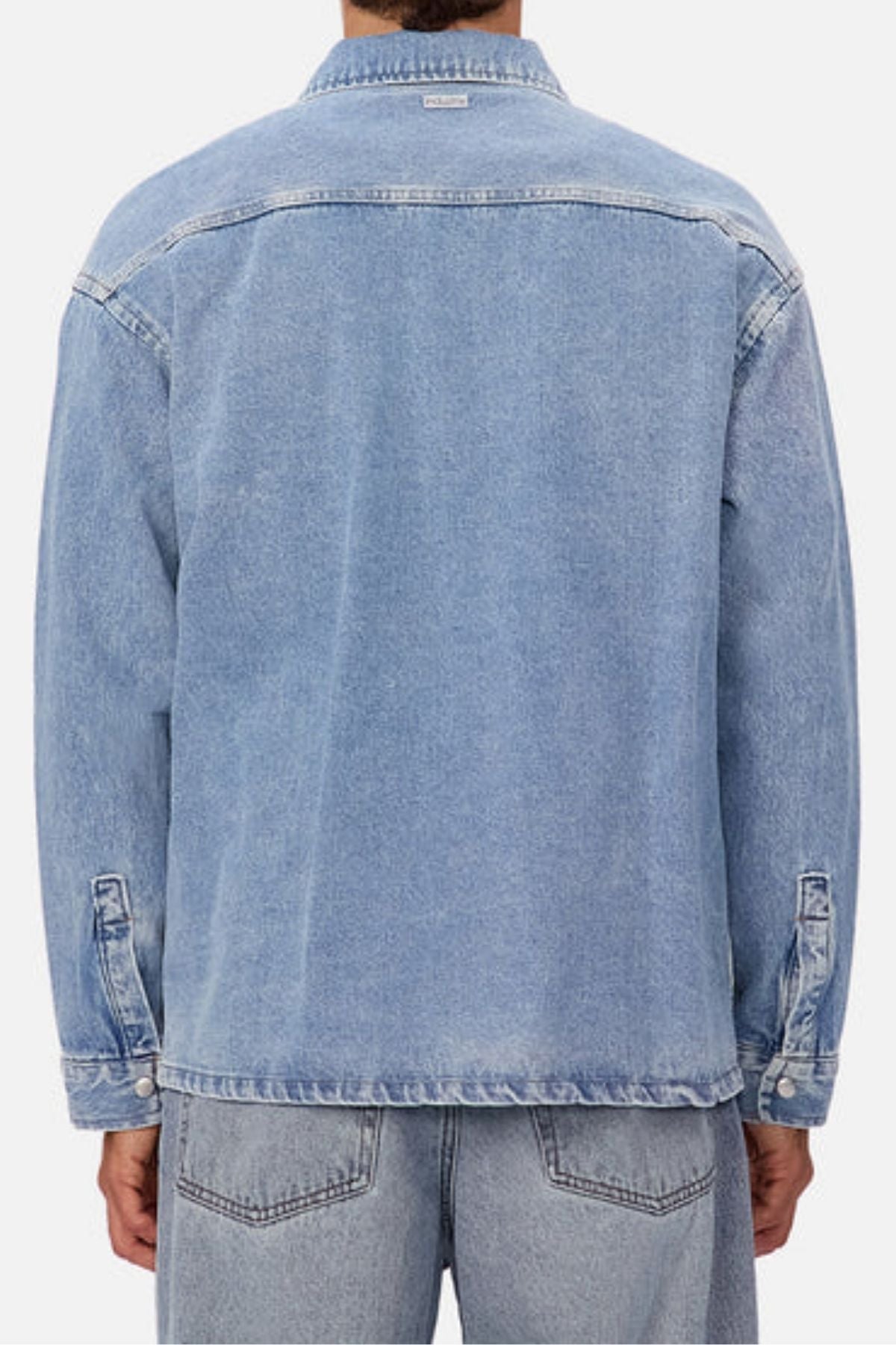 A person wearing the Industrie The Denim Overshirt in relaxed light blue denim with matching jeans, shown from the back against a plain white background for a cool vintage vibe.