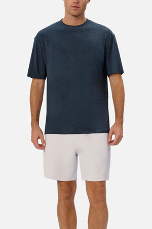 A man wearing the Industrie The Freeman Athletic Tee in dark blue and light gray shorts stands against a plain white background, facing forward with his arms relaxed at his sides.