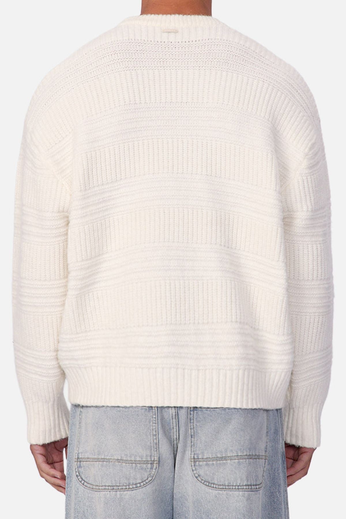 Person wearing an Industrie The Huntington Knit crew neck sweater with a textured pattern and light blue denim jeans, shown from the back against a plain background.