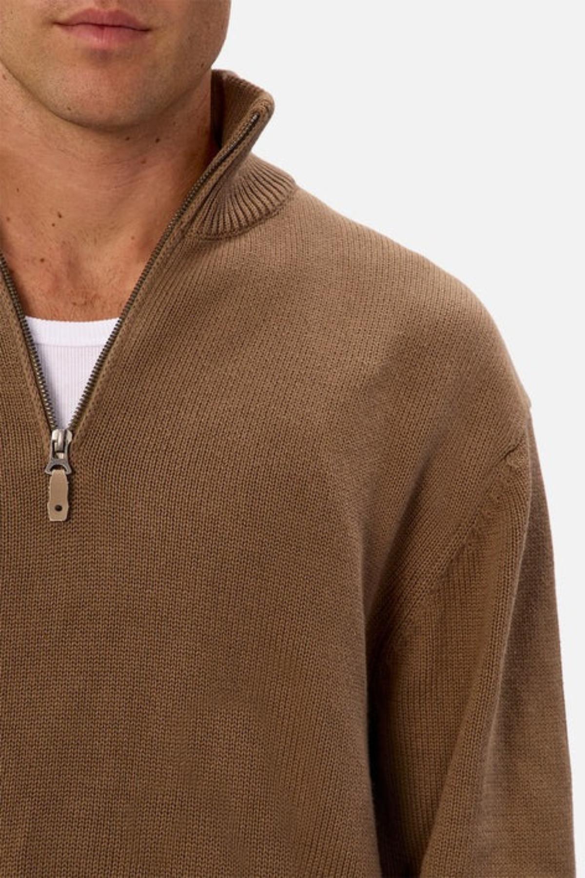 A man wears the Industrie The Maine Zip Neck Knit, a regular fit, heavyweight brown cotton quarter-zip sweater, layered over a white shirt. He is shown from the shoulders up against a plain background.