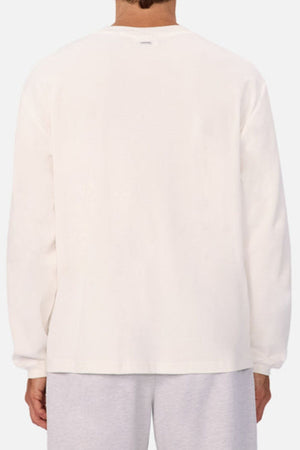 A person is seen from the back wearing Industrie The Marlon Long Sleeve Tee, crafted from 100% cotton textured fabric, and light gray pants, set against a light background.