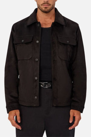 A man wears the Industrie The Monaco Jacket, featuring a lined torso and sleeves, over a black shirt and black pants, standing with arms relaxed at his sides against a plain light background.