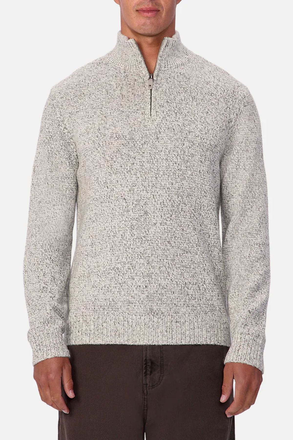 A person wears the Industrie The Montauk Knit—a light gray, marled zip-neck pullover sweater with a textured finish—paired with dark pants, standing against a plain white background.