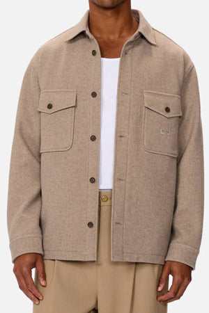 Wearing the Industrie The New Coleman Jacket—a light brown wool shirt jacket with classic collar and twin chest pockets—over a white tee and beige pants, shown from shoulders to mid-thigh.