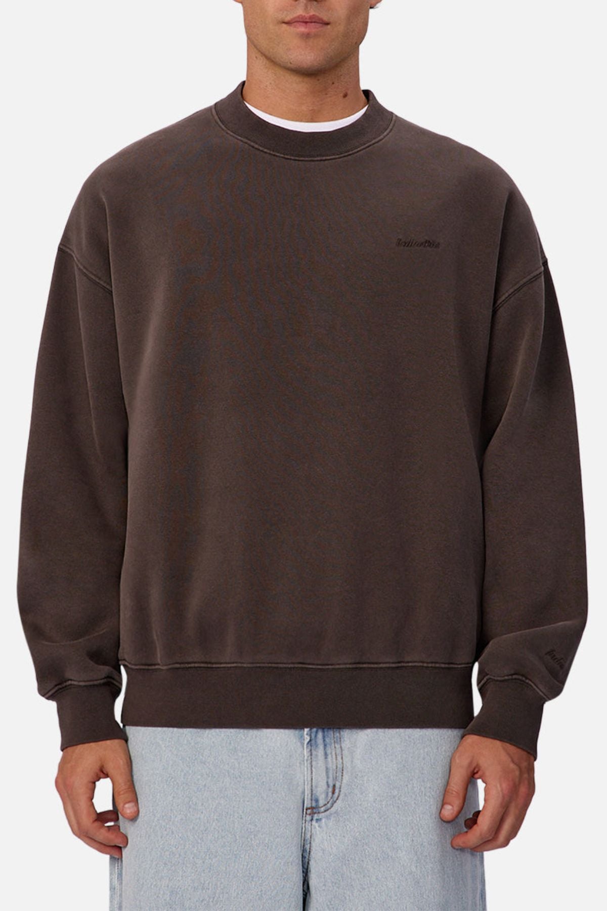 Someone wears the loose-fitting Industrie The New Del Sur Sweatshirt in dark brown with subtle chest branding and light blue jeans, standing against a plain white background.