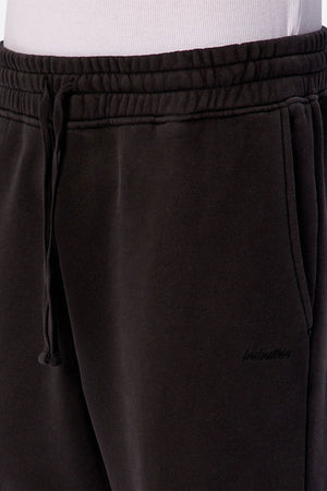 Close-up of a person wearing Industrie The New Del Sur Trackpant in black with a relaxed fit and visible waistband, paired with a white shirt—ideal men's loungewear.