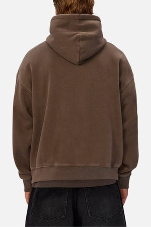 A person is seen from behind in an oversized fit, wearing the Industrie The New Del Sur Washed Hoodie in brown with the hood up and dark jeans, set against a plain light background that highlights the relaxed style.