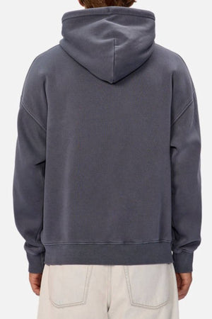 A person is seen from behind wearing the Industrie The New Del Sur Washed Hoodie in dark gray with an oversized fit and off-white pants, hood up, set against a plain light-colored background.