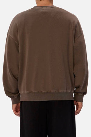 Person wearing an oversized fit, brown Industrie The New Del Sur Washed Sweat with long sleeves and ribbed cuffs and hem, seen from the back against a plain background.