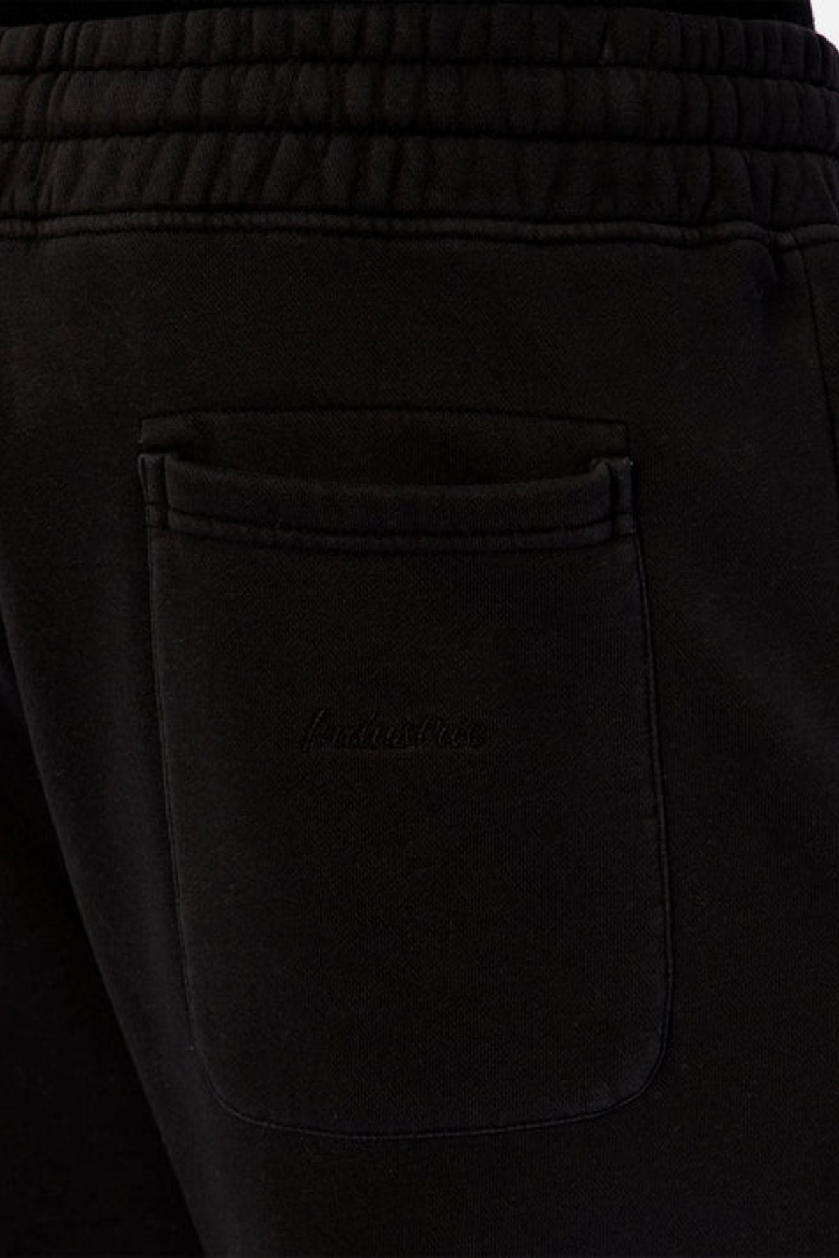 Close-up of the back pocket on the Industrie The New Del Sur Washed Trackpant, a black sweatpant featuring a drawstring waist, elastic waistband, subtle logo detailing on the pocket, and elasticated cuffed ankles.
