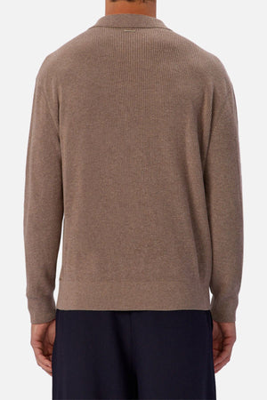 A person is seen from behind wearing the Industrie The New England Polo Knit in light brown with black pants, standing against a plain white background.