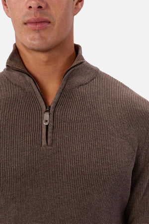 A person wearing the Industrie The New England Zip Neck Knit in brown. The ribbed sweater’s zipper is partially open, with the image cropped to show the lower face, neck, and upper torso.