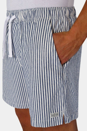 A person is wearing the Industrie The New Southwest Short, showcasing fashionable blue and white vertical stripes. It comes with an elasticated waistband and a white drawstring, while one hand casually rests in the pocket against a plain white background.