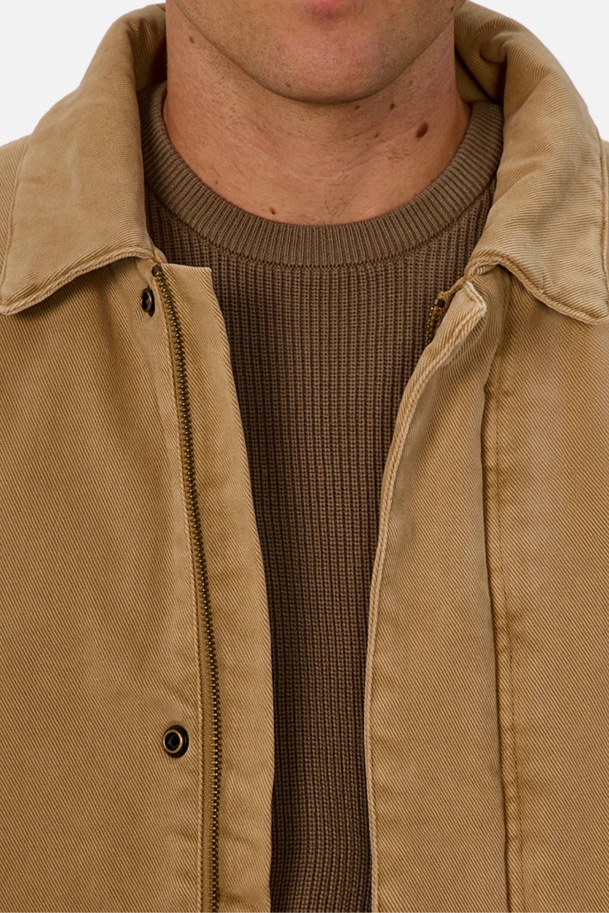 A close-up of a person wearing the Industrie The Oklahoma Jacket over a brown ribbed sweater. The shot highlights the casual-fit jacket’s clean lines, showing only the lower face and upper chest.