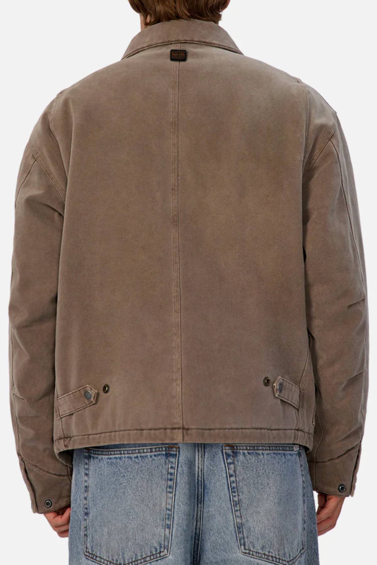 A person is seen from behind wearing the Industrie The Oklahoma Jacket, featuring button details on the back, styled with light blue denim jeans against a plain background.