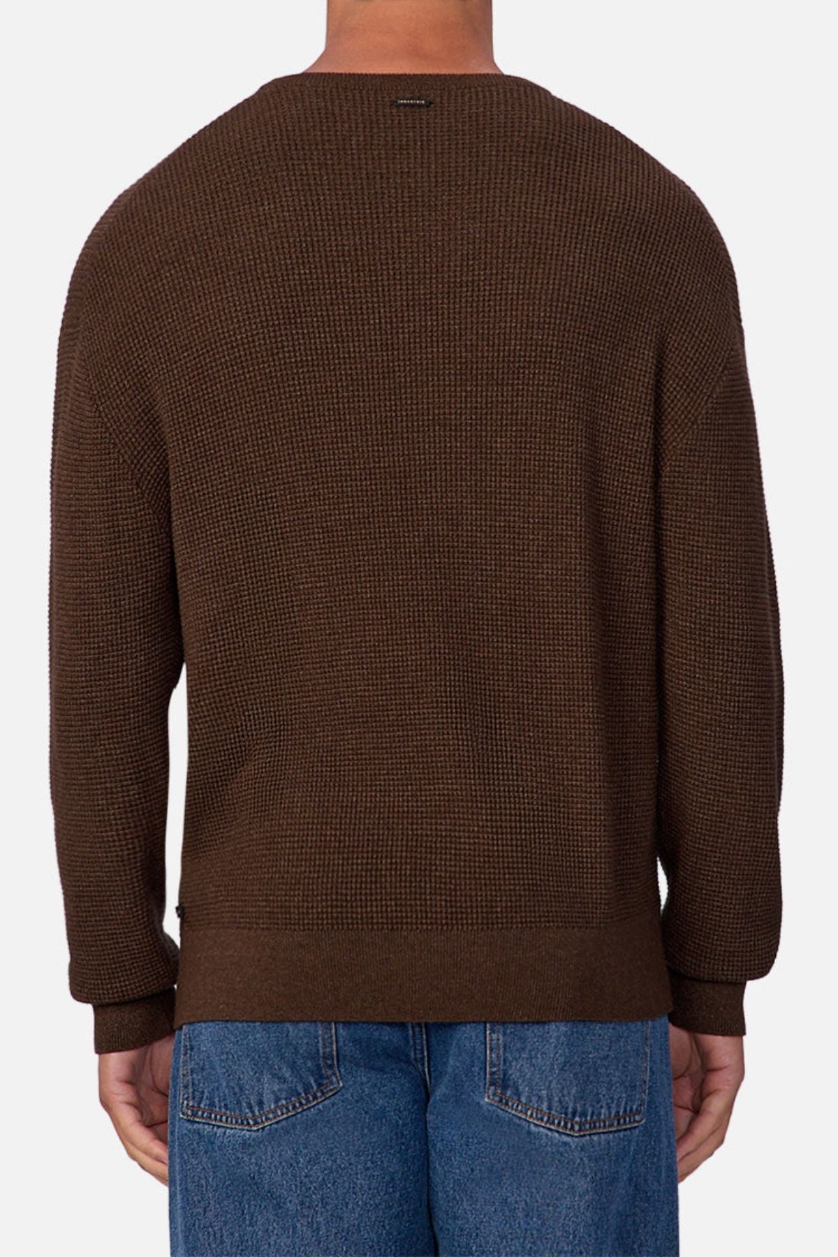 A person is shown from the back against a plain white background, wearing Industrie The Philly Waffle Knit sweater in textured brown and blue jeans.