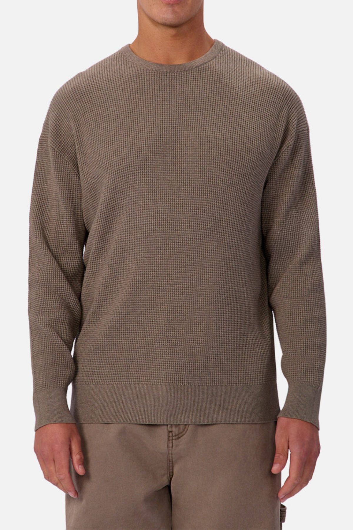 Someone is wearing the Industrie The Philly Waffle Knit, a textured long-sleeve crew neck sweater in light brown, paired with matching pants and standing against a plain light background.