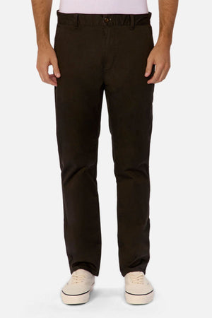A person models the Industrie The Regular Cuba Chino Pant, made from stretch cotton blend, paired with white sneakers. Only the lower half is visible, highlighting the wider leg fit against a plain white background.