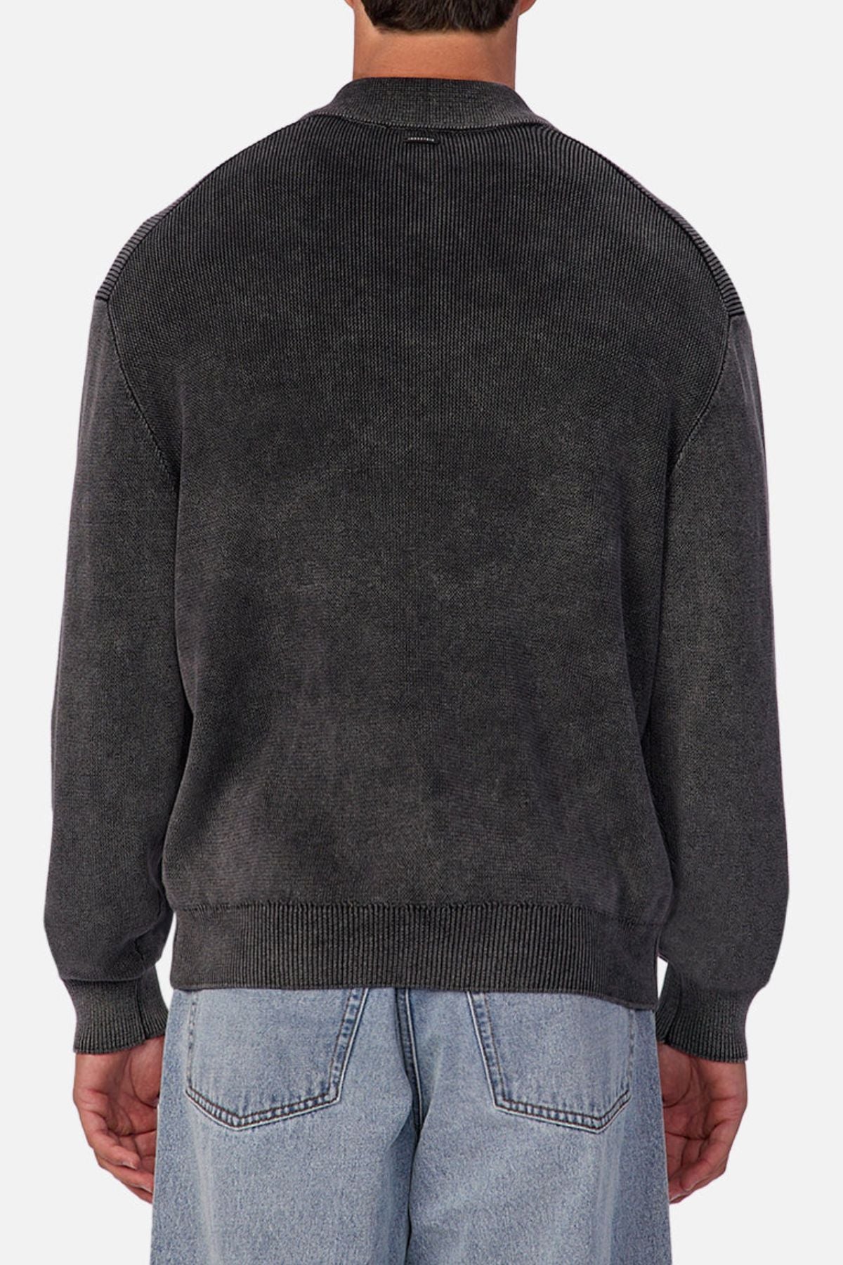 A person is shown from the back wearing the Industrie The Sawtelle Knit—a dark gray, long-sleeve sweater—paired with light blue jeans, perfect for everyday wear. The background is plain and light-colored.