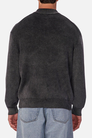 A person is shown from the back wearing the Industrie The Sawtelle Knit—a dark gray, long-sleeve sweater—paired with light blue jeans, perfect for everyday wear. The background is plain and light-colored.