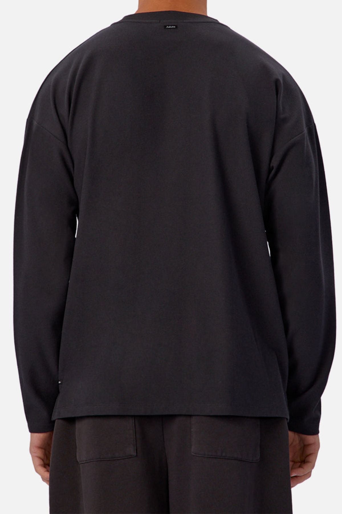 A person is shown from behind wearing the Industrie The Waffle Long Sleeve Tee in black with matching shorts, set against a plain light background.