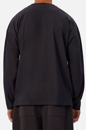 A person is shown from behind wearing the Industrie The Waffle Long Sleeve Tee in black with matching shorts, set against a plain light background.