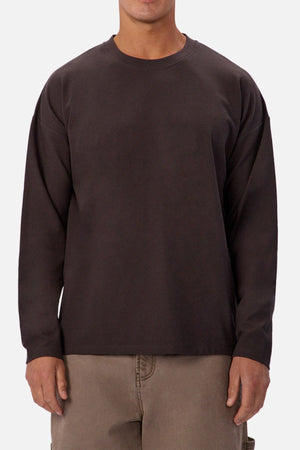 A person wears the Industrie The Waffle Long Sleeve Tee in dark brown with light brown pants, standing against a plain white background.