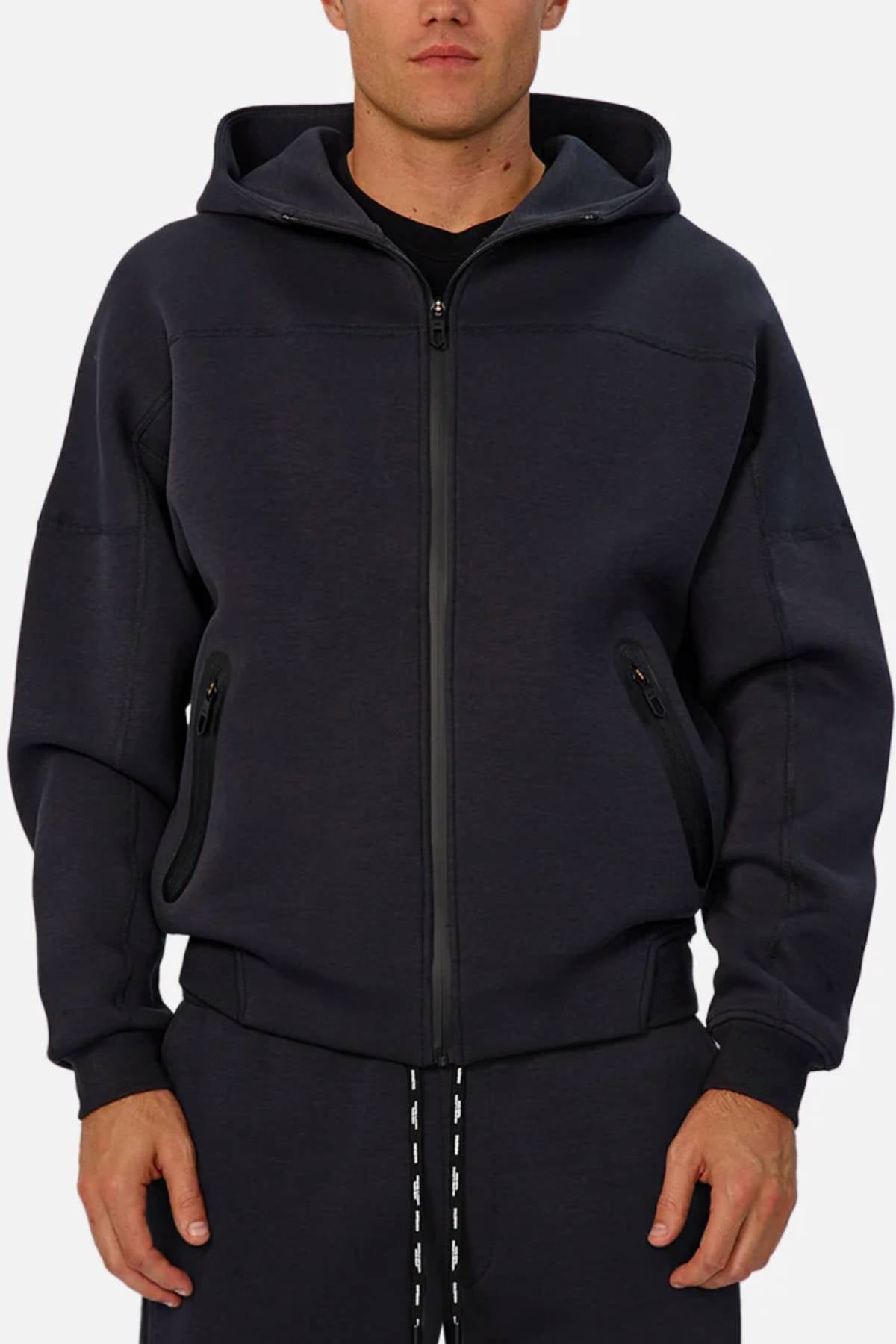 A man in the Industrie The Washington Zip Thru jacket with a hood and matching joggers stands facing forward, hands relaxed at his sides—making this look ideal for everyday style.