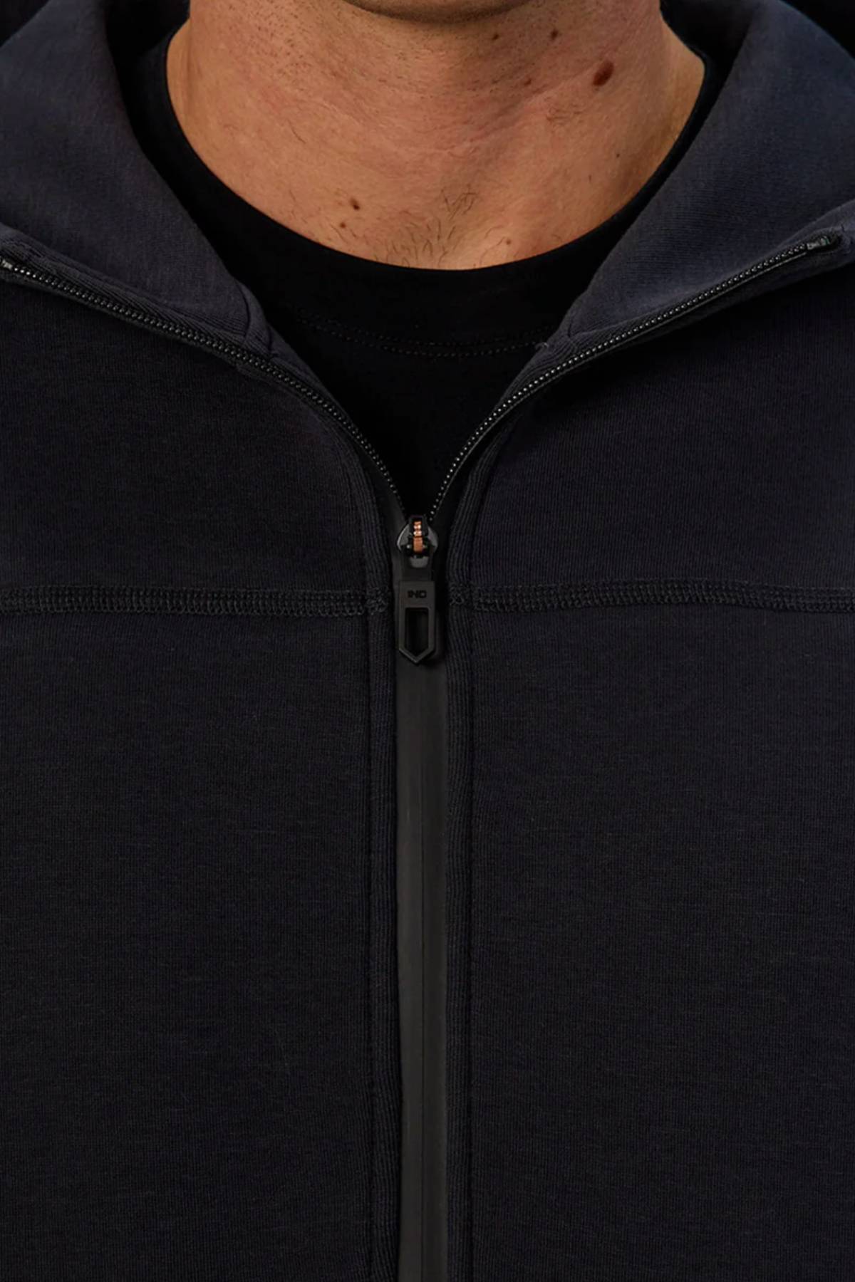 Close-up of a person wearing the Industrie The Washington Zip Thru over a black shirt, showing only their lower face and neck. The jacket's zipper is centered and partially zipped, ideal for everyday style.
