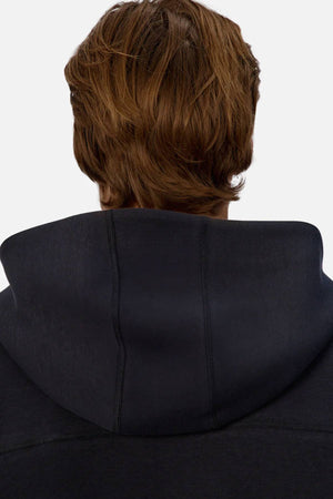 A person with medium-length brown hair is seen from behind, wearing the Industrie The Washington Zip Thru jacket with the hood down against a light, plain background, highlighting its versatile everyday appeal.