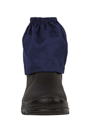 A front view of a black shoe wearing a blue JBs Boot Cover, made from cotton drill, around the ankle on a plain white background.