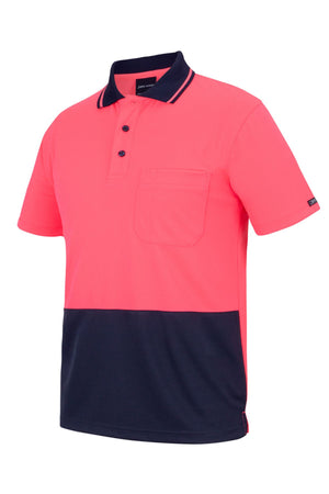 The JBs Hi Vis Non Cuff Traditional Polo is a short-sleeve 100% polyester shirt with a bright pink upper, black collar and cuffs, black buttons, a left chest pocket, and a sleek black lower section.