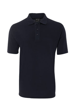 The JBs Short Sleeve Polo, shown on a white background, is a plain black shirt with a classic collar and three-button placket. Crafted for durability and UPF protection, it’s ideal for everyday comfort.