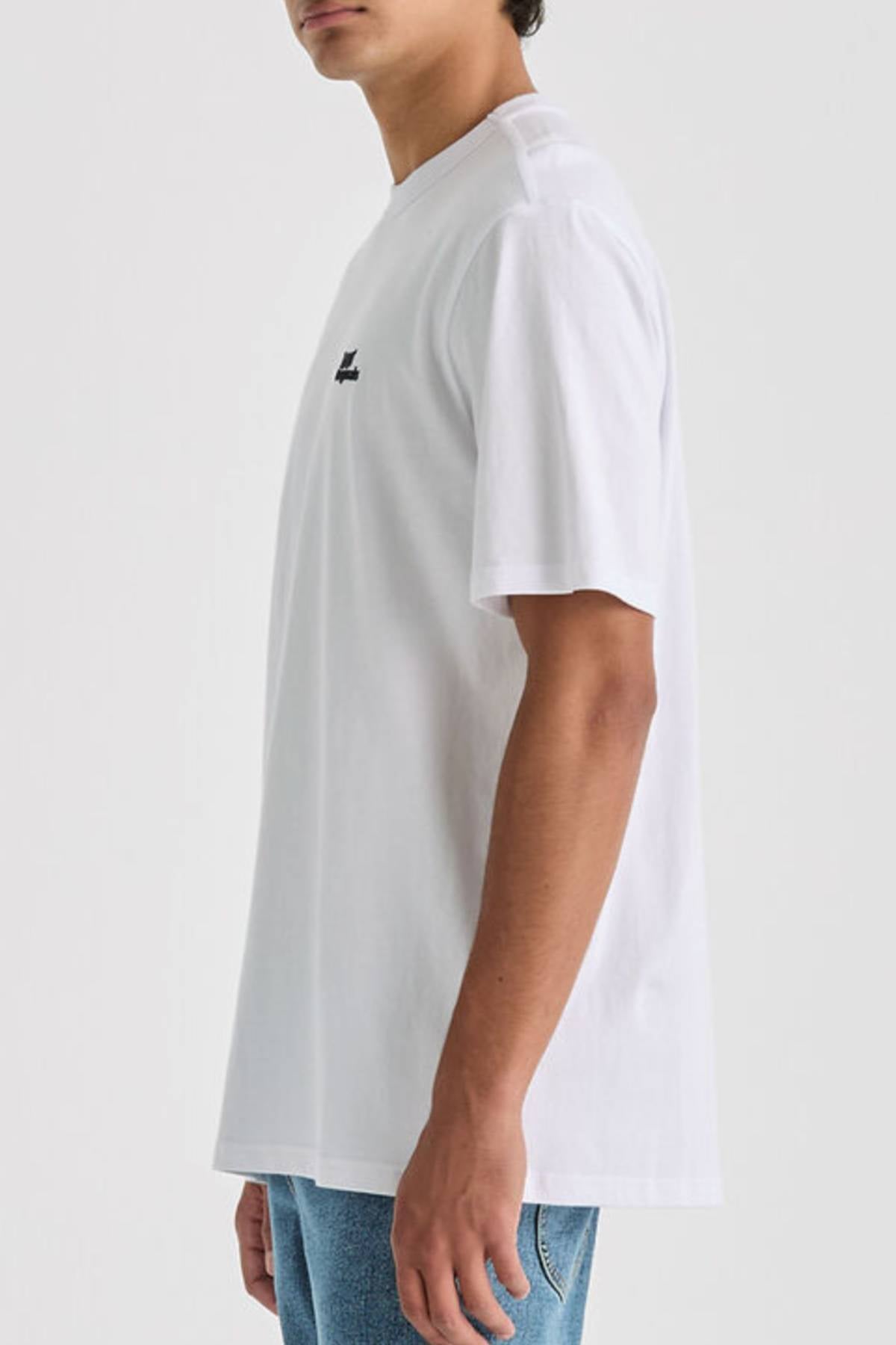 A person wearing a plain white Lee Originals Relaxed Tee and blue jeans stands sideways against a light gray background, with only their upper half visible.