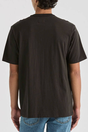 Someone in the Lee Originals Relaxed Tee, a plain black 100% cotton T-shirt, paired with blue jeans, stands facing away against a light gray background.
