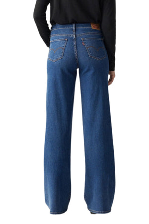 A person wearing Levis 318 Shaping Wide Leg Jean and a black long-sleeve top is shown from the back against a white background.