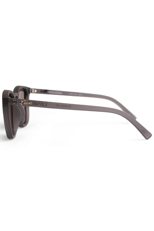A side view of the Liive Manhattan Polar Sunglasses reveals the inscription "Manhattan" and "CE" on the arms. The brand name in gold complements its sleek, modern design with wide arms, while the polarized lenses offer enhanced style and clarity in bright conditions.