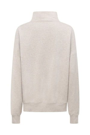 The Lorna Jane LJC Heritage Quarter Zip Sweat in light beige is shown from the back, with a high collar, ribbed cuffs and hem. Made from soft cotton terry fabric, it features a simple design with no visible logos or patterns.