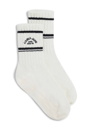 A pair of Lorna Jane Lotus Limited Edition Quarter Crew Socks in white, featuring two black stripes near the top and "Lorna Jane Lucky 13 Est. 1990" text in black on the side.