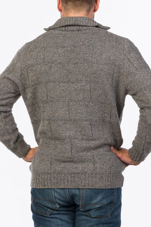 A person wearing the MKM Marlborough gray textured Merino Wool Knit sweater and blue jeans is standing with their back to the camera, hands on hips, against a plain white background.