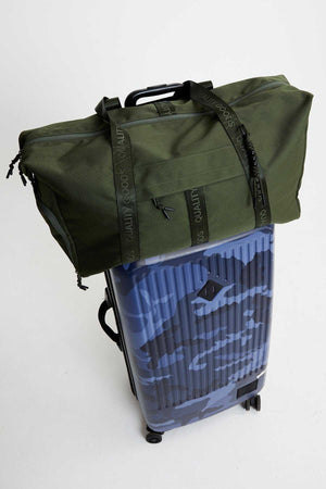 A green Mr Simple Nelson Duffle bag rests on a blue and black camo-patterned wheeled suitcase. The suitcase handle is extended, set against a plain white background, ready for travel with these quality items.