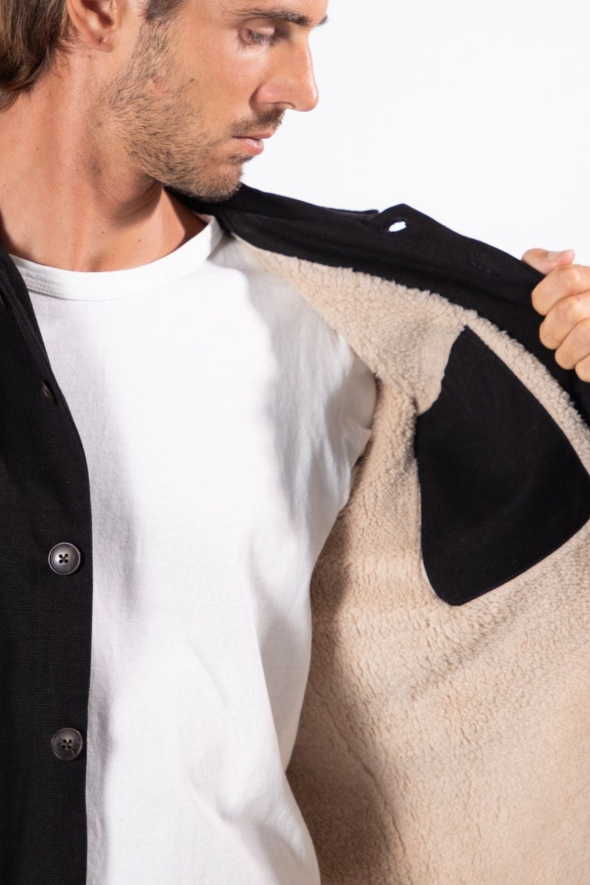 A man in a white t-shirt opens a Mr Simple Stockyard Sherpa Jacket, revealing its warm beige fleece lining and Regular Fit, set against a plain white background.