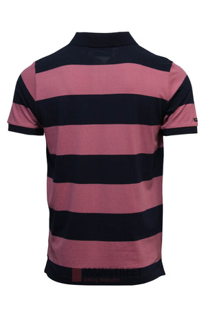 The Pilbara Striped Polo is a 100% cotton shirt with wide dark navy and muted pink stripes, shown from the back. It features a classic collar, short sleeves, and a straight hem for a timeless look.